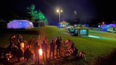Atmosphäre des Zeltens vom September 2022 mit Menschen am Lager zur Dämmerung und Blick auf den Zeltplatz
